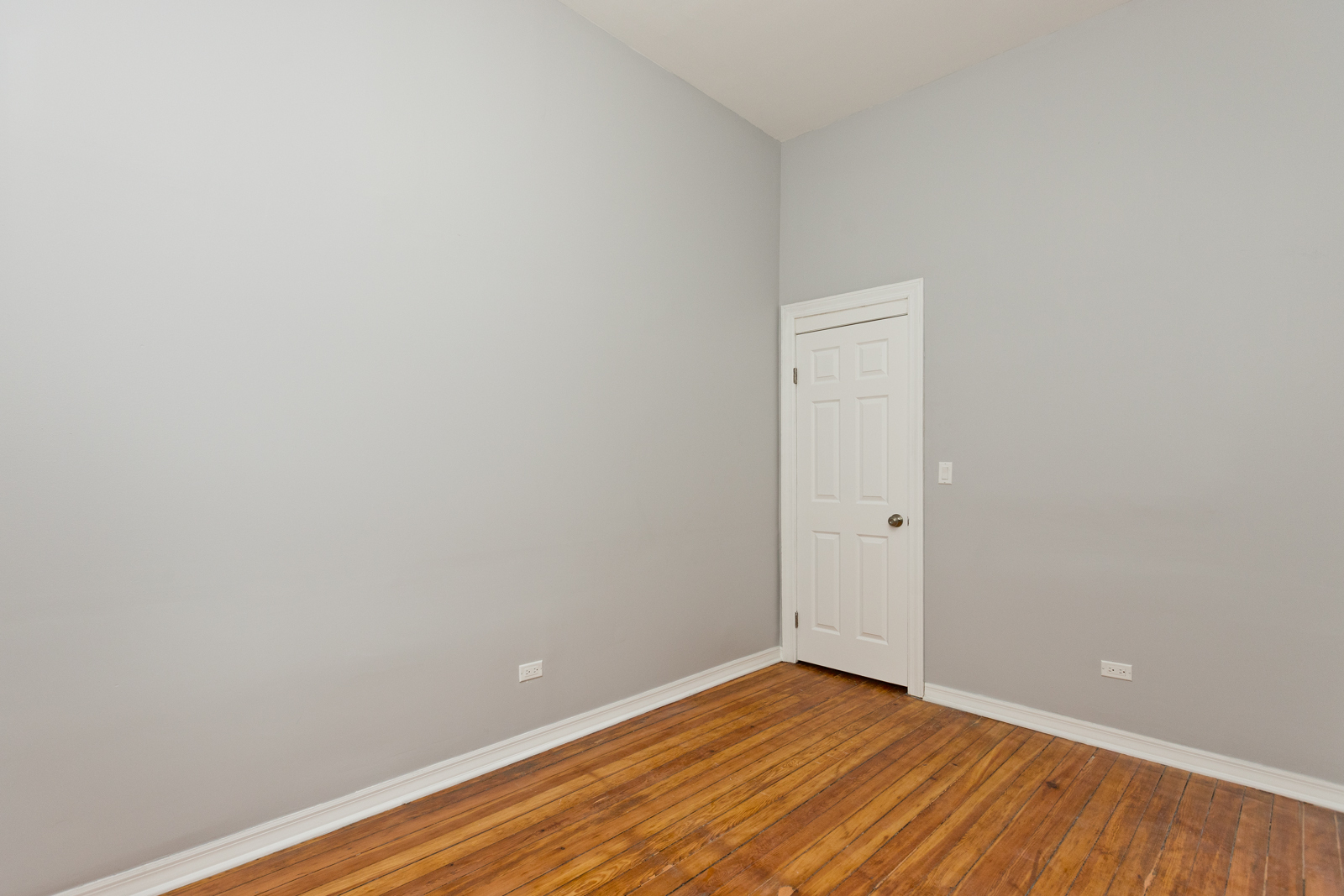 1300 West Addison Street, Unit 1 Chicago, IL 60613 - Photo 10 of 14 a view of an empty room with wooden floor and a window