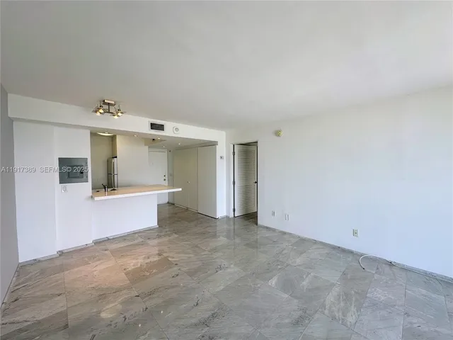 an aerial view of ocean and residential houses with outdoor space