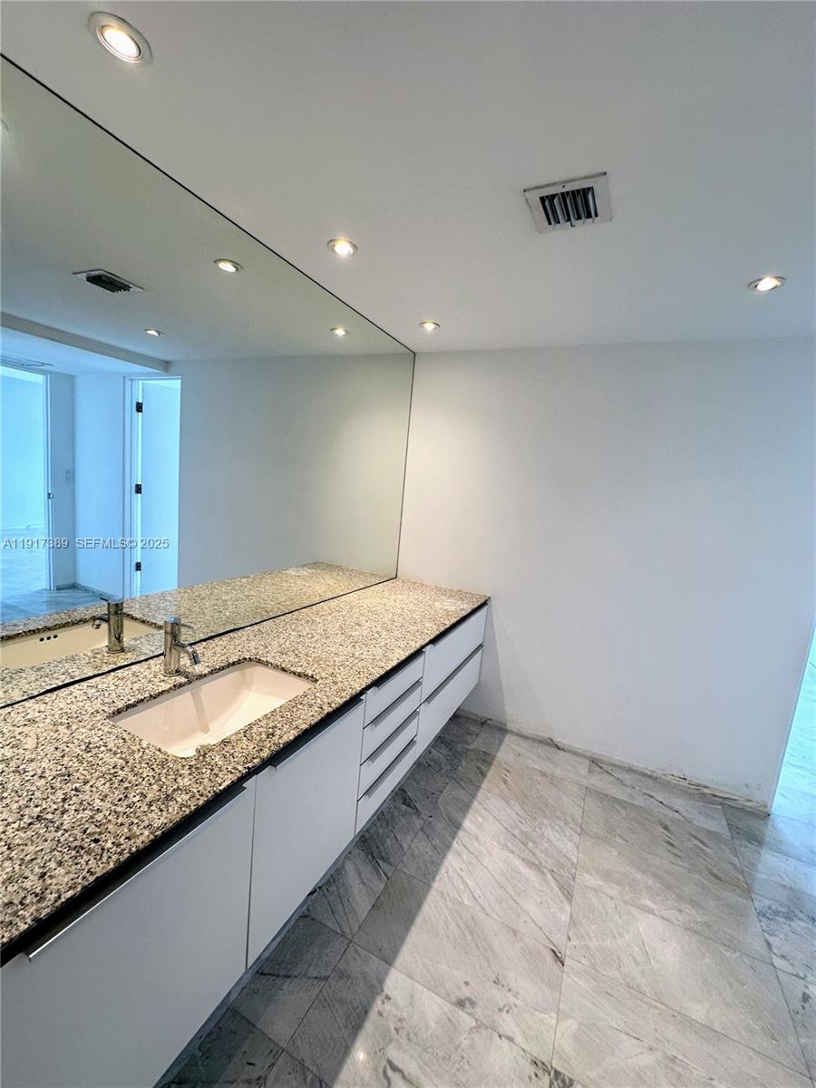 2350 Northeast 135th Street, Unit 1501 North Miami, FL 33181 - Photo 6 of 13 a bathroom with a granite countertop sink and a large mirror