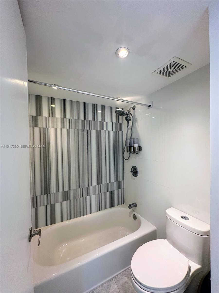 2350 Northeast 135th Street, Unit 1501 North Miami, FL 33181 - Photo 7 of 13 a bathroom with a toilet and a bathtub