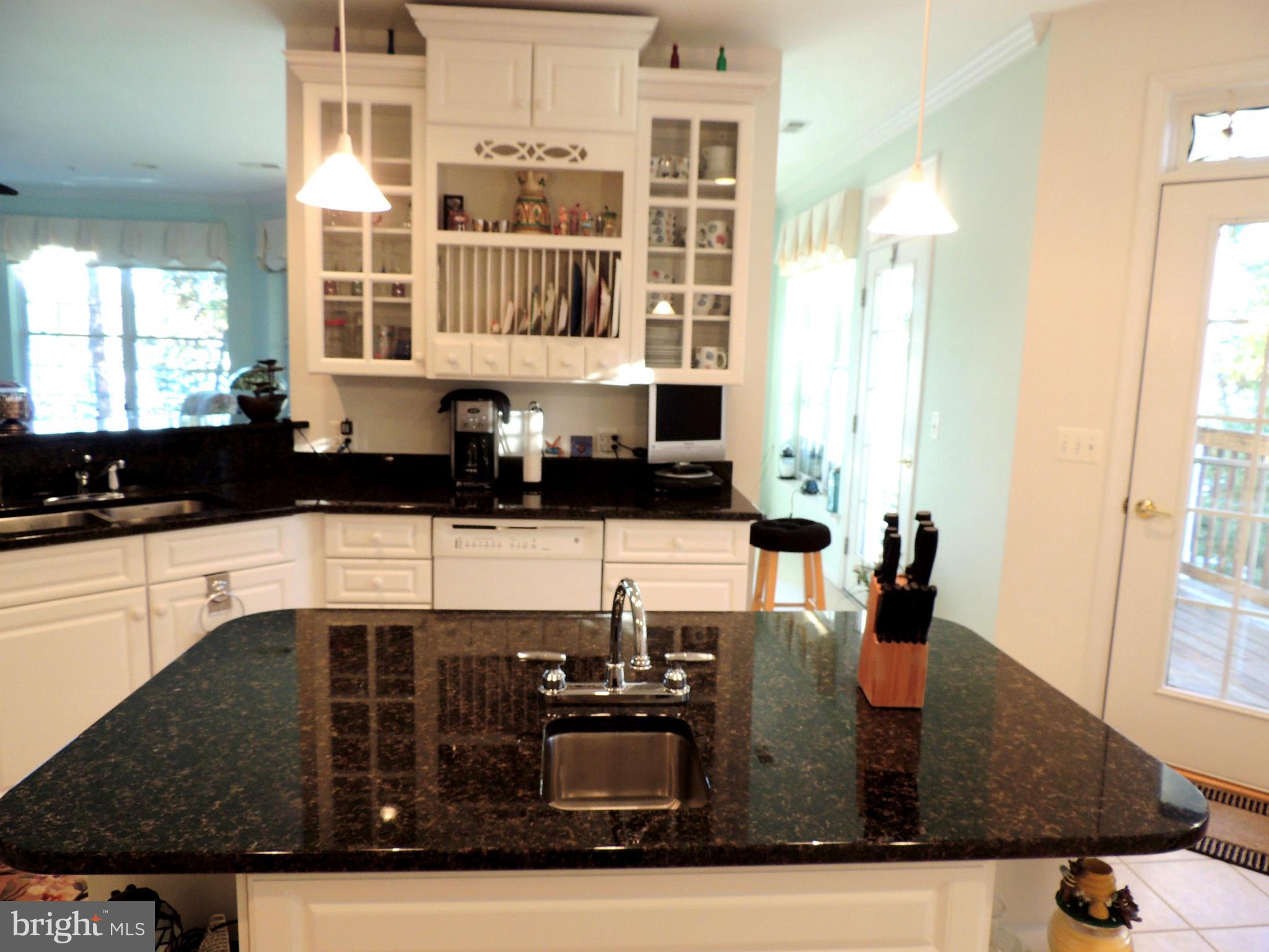 722 Runabout Loop, Unit 722 Solomons, MD 20688 - Photo 11 of 30 a kitchen with kitchen island granite countertop a sink and cabinets