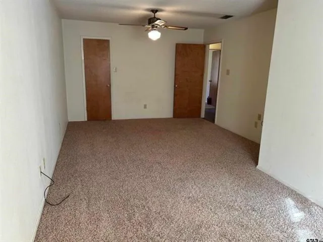 an empty room with fan and entrance
