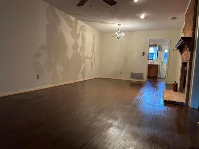 an empty room with wooden floor and a window
