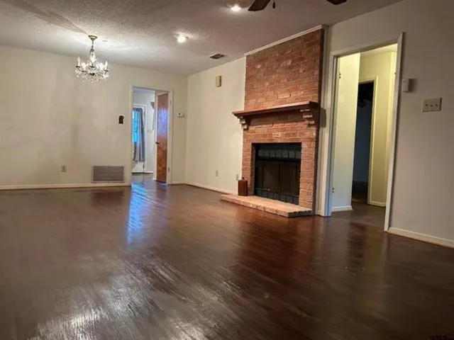 a view of a livingroom with wooden floor a fireplace and window