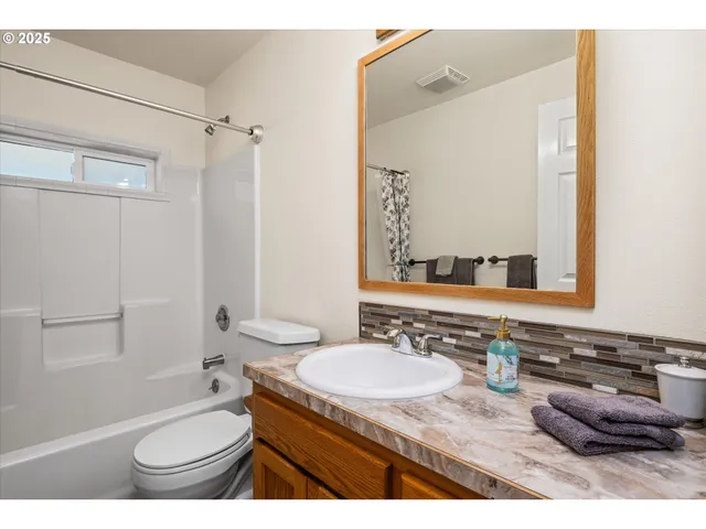 a bathroom with a granite countertop sink toilet a mirror and shower