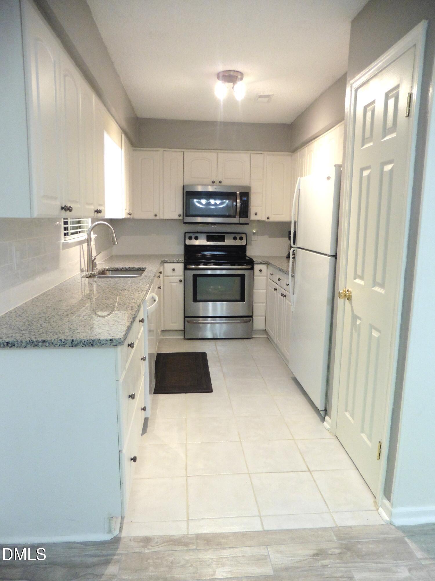 4257 Lake Ridge Drive Raleigh, NC 27604 - Photo 12 of 19 a kitchen with granite countertop a refrigerator and a sink