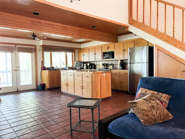 a kitchen with stainless steel appliances kitchen island granite countertop a refrigerator and microwave