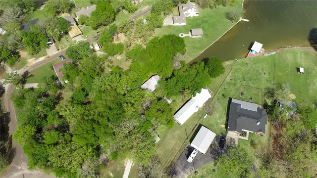 an aerial view of a house with a yard and large trees