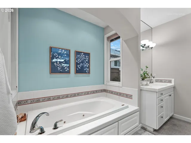 a bathroom with a tub a sink and mirror