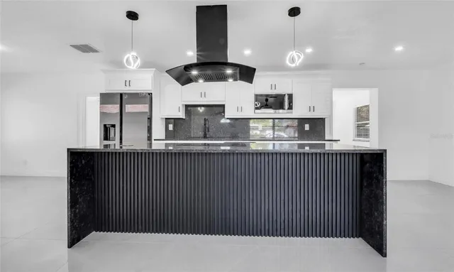 a kitchen with stainless steel appliances granite countertop a refrigerator a sink and a stove