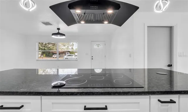 a kitchen with granite countertop white cabinets and white appliances