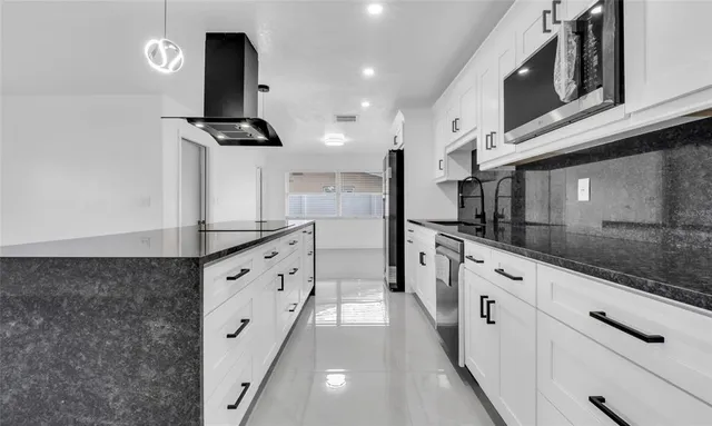 a large kitchen with stainless steel appliances kitchen island a refrigerator sink and cabinets