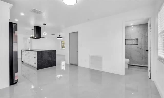 a kitchen with stainless steel appliances kitchen island sink refrigerator and microwave