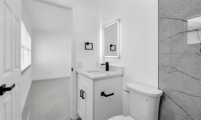 a bathroom with a toilet sink and mirror