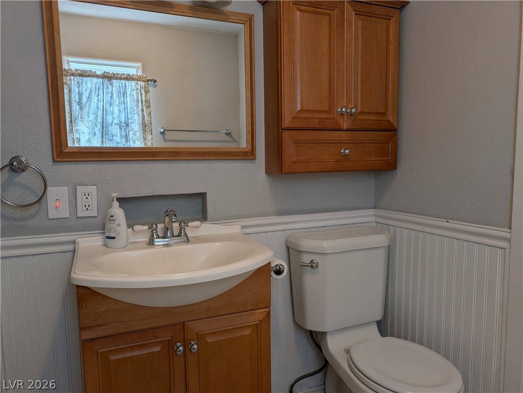 1 South 5th Street Panaca, NV 89042 - Photo 12 of 21 Full bathroom with wainscoting, vanity, and a textured wall
