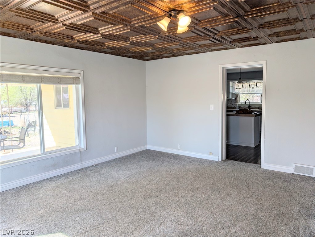 1 South 5th Street Panaca, NV 89042 - Photo 4 of 21 Living Room featuring an ornate ceiling and carpet floors