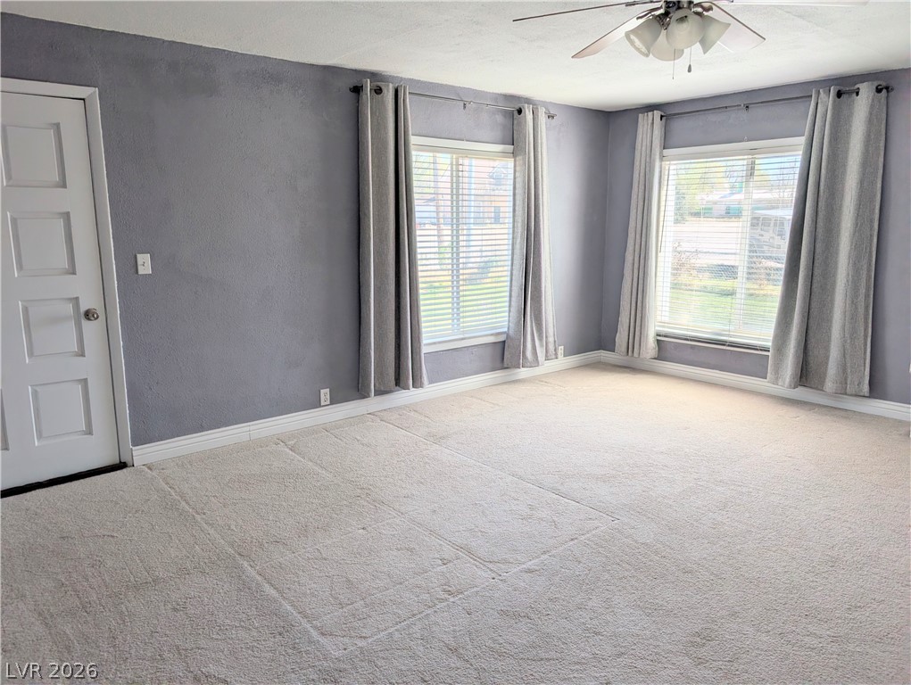 1 South 5th Street Panaca, NV 89042 - Photo 9 of 21 Carpeted primary bedroom with ceiling fan, plenty of natural light, and a textured wall, and exterior exit