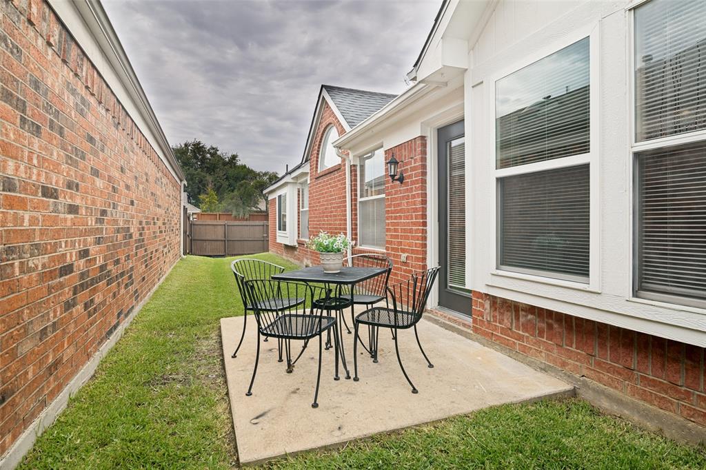 3020 Ridge Hollow Drive Plano, TX 75023 - Photo 26 of 28 Brick exterior featuring a concrete patio, exterior lighting fixture, and a side yard with a privacy fence