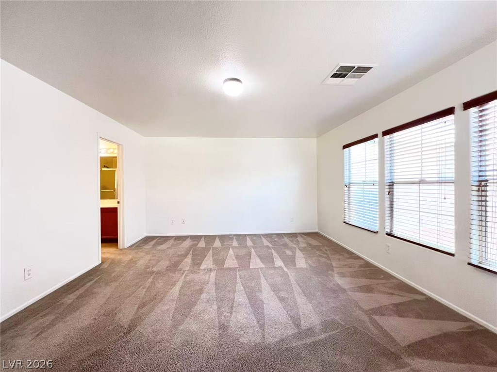 11143 Ranch Valley Street Las Vegas, NV 89179 - Photo 15 of 23 A spacious room featuring plush carpet and windows with natural light.