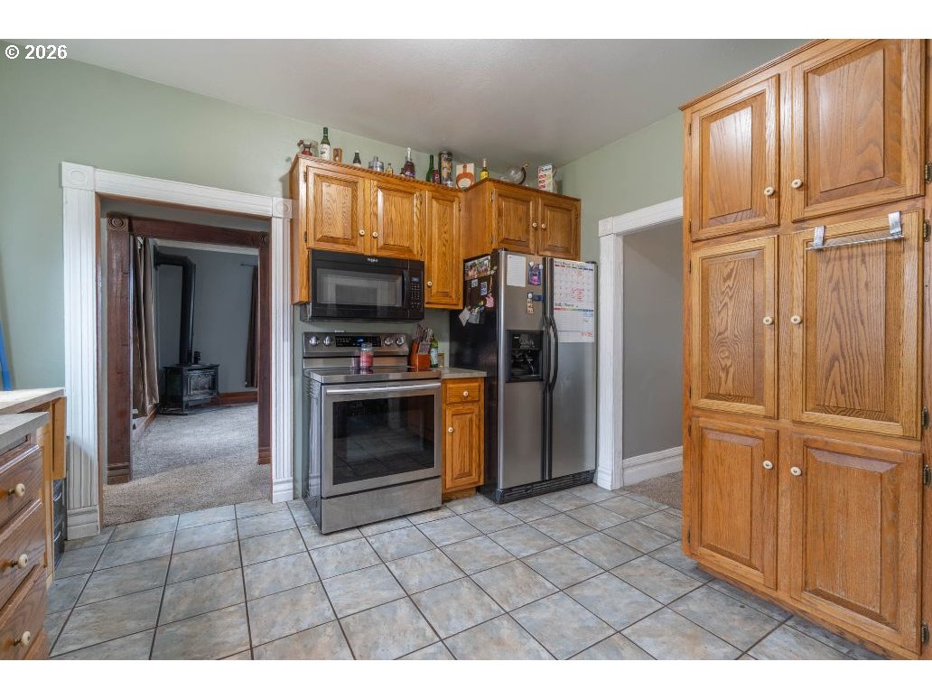243 North Lane Street Cottage Grove, OR 97424 - Photo 3 of 22 a kitchen with granite countertop a refrigerator and a stove top oven