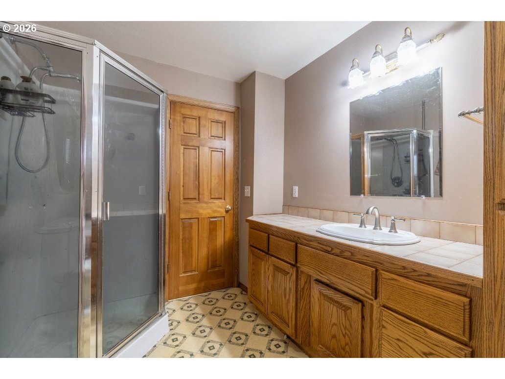 243 North Lane Street Cottage Grove, OR 97424 - Photo 9 of 22 a bathroom with a sink a mirror and a shower