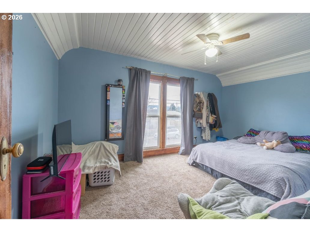 243 North Lane Street Cottage Grove, OR 97424 - Photo 10 of 22 a bedroom with a bed next to a window with chair