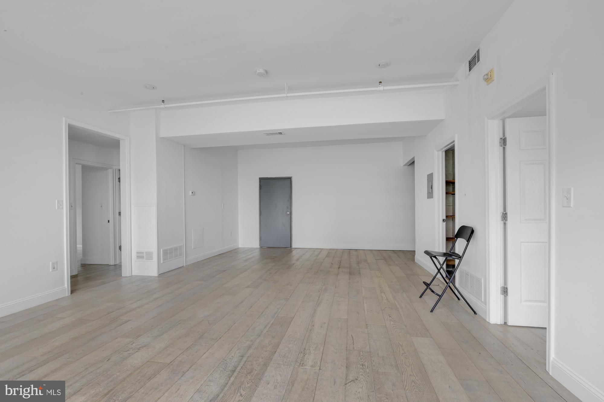 301 Spring Garden Street, Unit 3B Philadelphia, PA 19123 - Photo 4 of 22 a view of empty room with wooden floor and fan