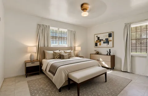 a bedroom with a bed wooden floor and window