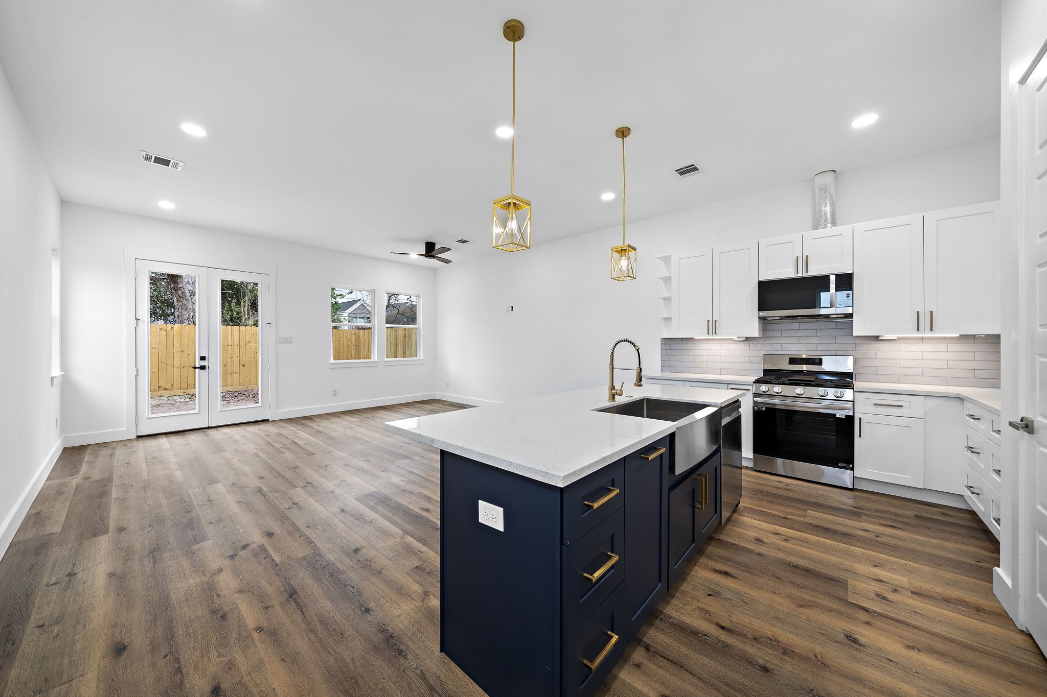a kitchen with a stove a sink and wooden floor