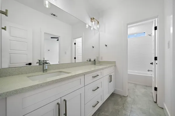 a bathroom with double vanity sink and a mirror