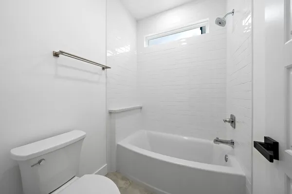 a white bath tub sitting next to a toilet