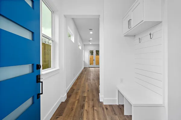 a view of a hallway with wooden floor and staircase