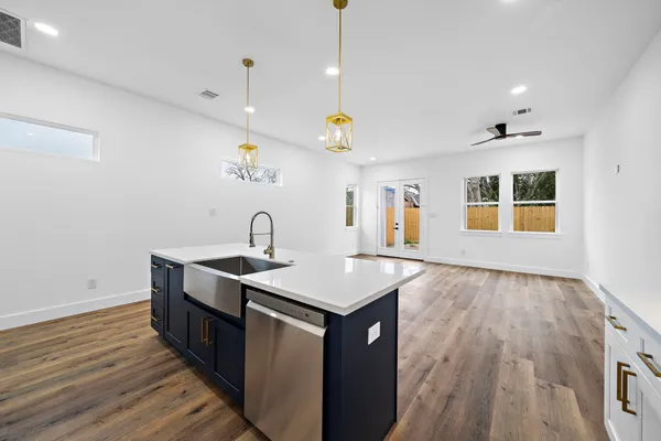 a kitchen with kitchen island a sink and wooden floor