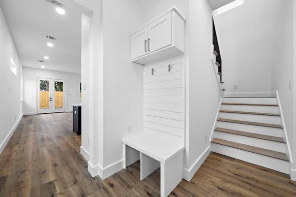 a view of a hallway with wooden floor and entryway