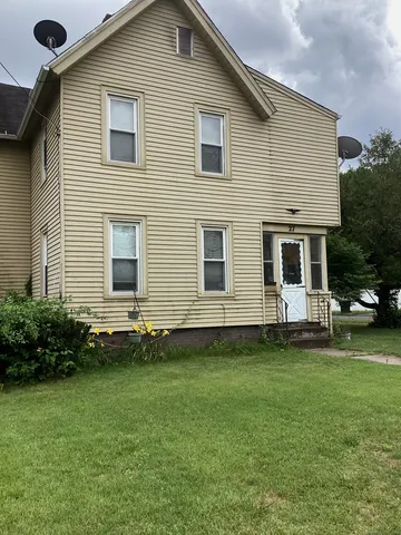 a front view of a house with a garden