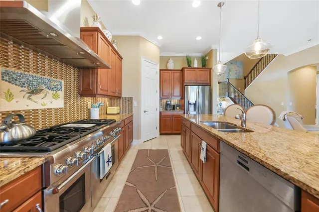 a kitchen with stainless steel appliances granite countertop a stove a sink dishwasher and a refrigerator
