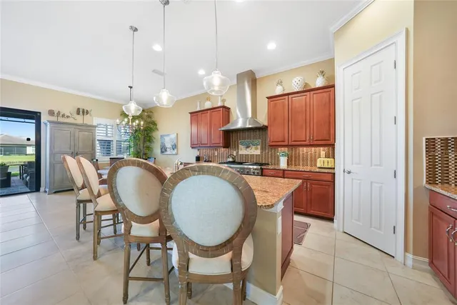 a kitchen with stainless steel appliances granite countertop a dining table chairs and a refrigerator