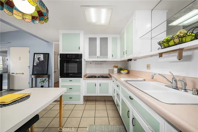 a kitchen with stainless steel appliances kitchen island granite countertop a stove a white cabinets a dining table and chairs with wooden floor
