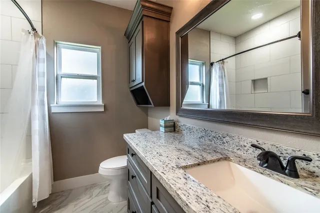 a bathroom with a granite countertop sink a mirror and a bathtub