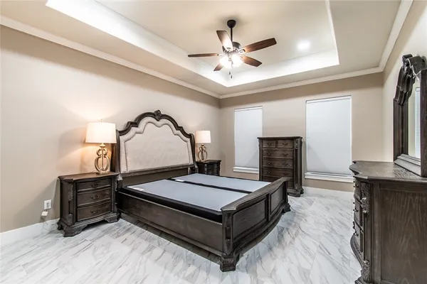a room with a bed and ceiling fan
