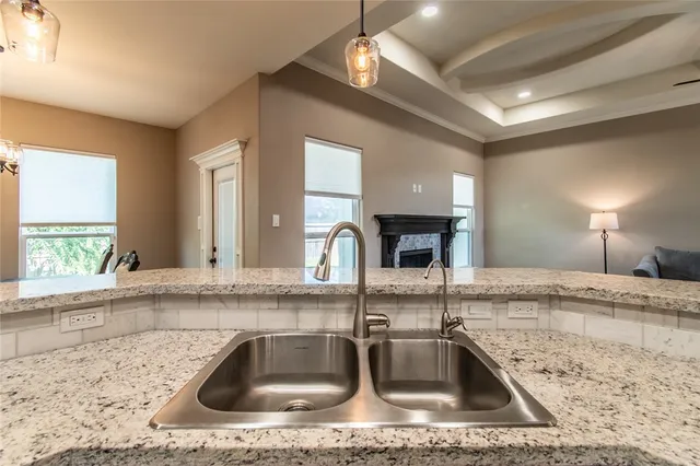 a kitchen with a stove center island a window and living room view