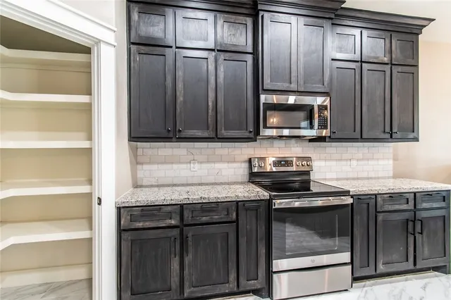a kitchen with granite countertop a refrigerator and cabinets
