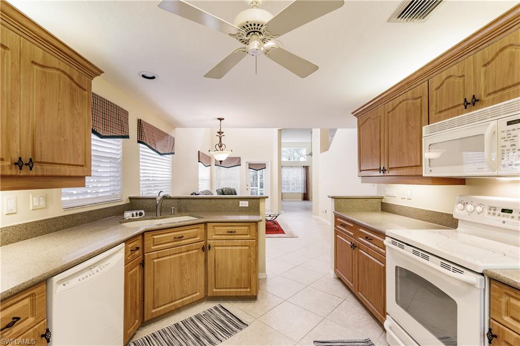 131 Napa Ridge Way Naples, FL 34119 - Photo 13 of 34 a kitchen with stainless steel appliances a sink stove and cabinets