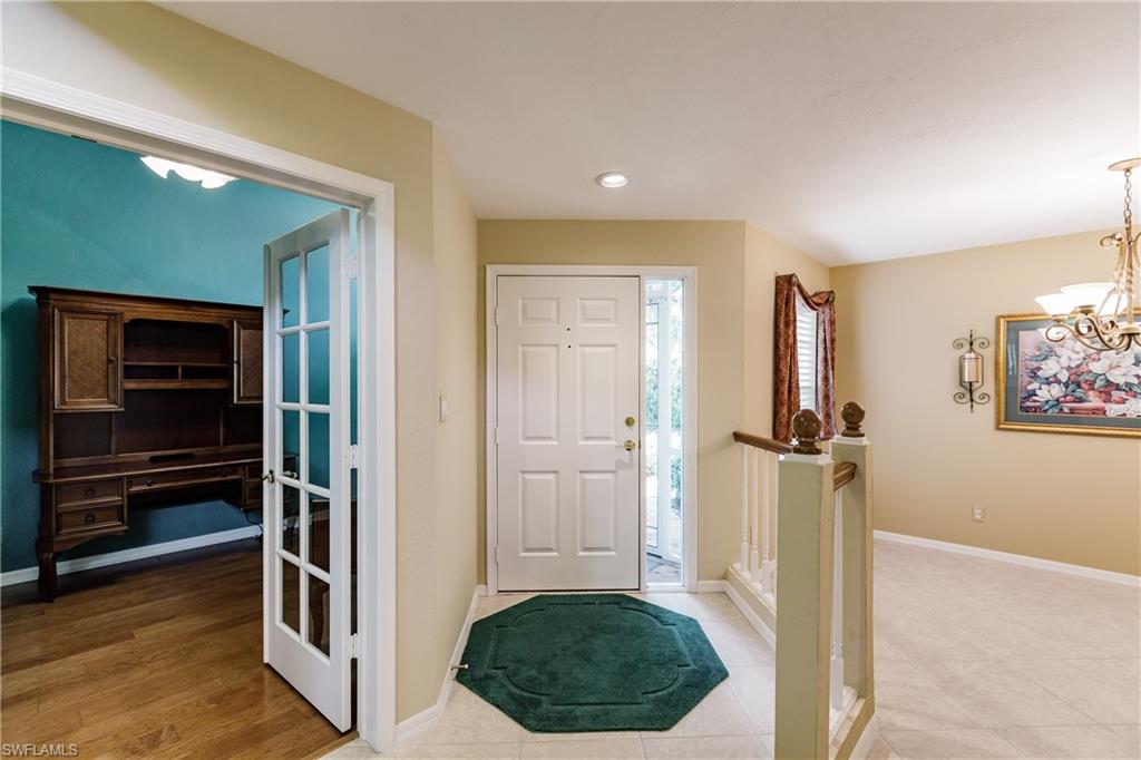 131 Napa Ridge Way Naples, FL 34119 - Photo 4 of 34 a view of a hallway with wooden floor and closet