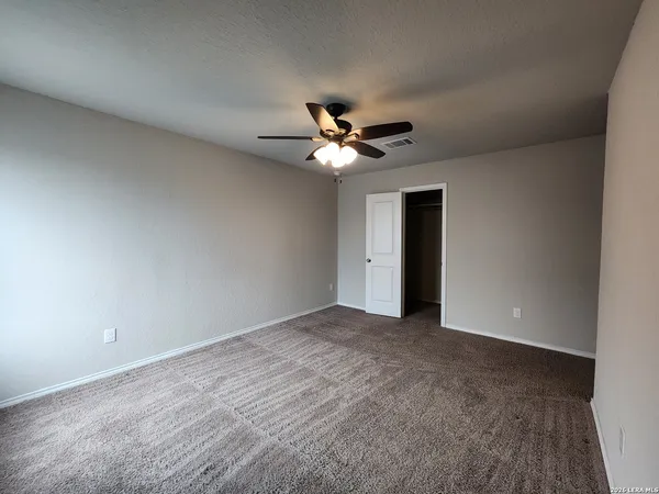 a view of an empty room with a ceiling fan