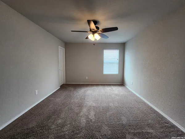 an empty room with a window and a fan