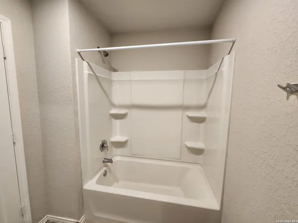 a white bath tub with shower in it