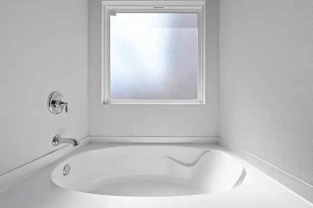 a bathroom with a tub sink and window