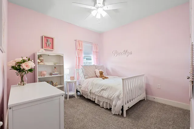 a living room with furniture a flat screen tv and floor to ceiling window