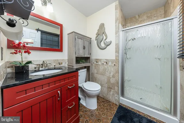 a bathroom with a granite countertop sink toilet and shower